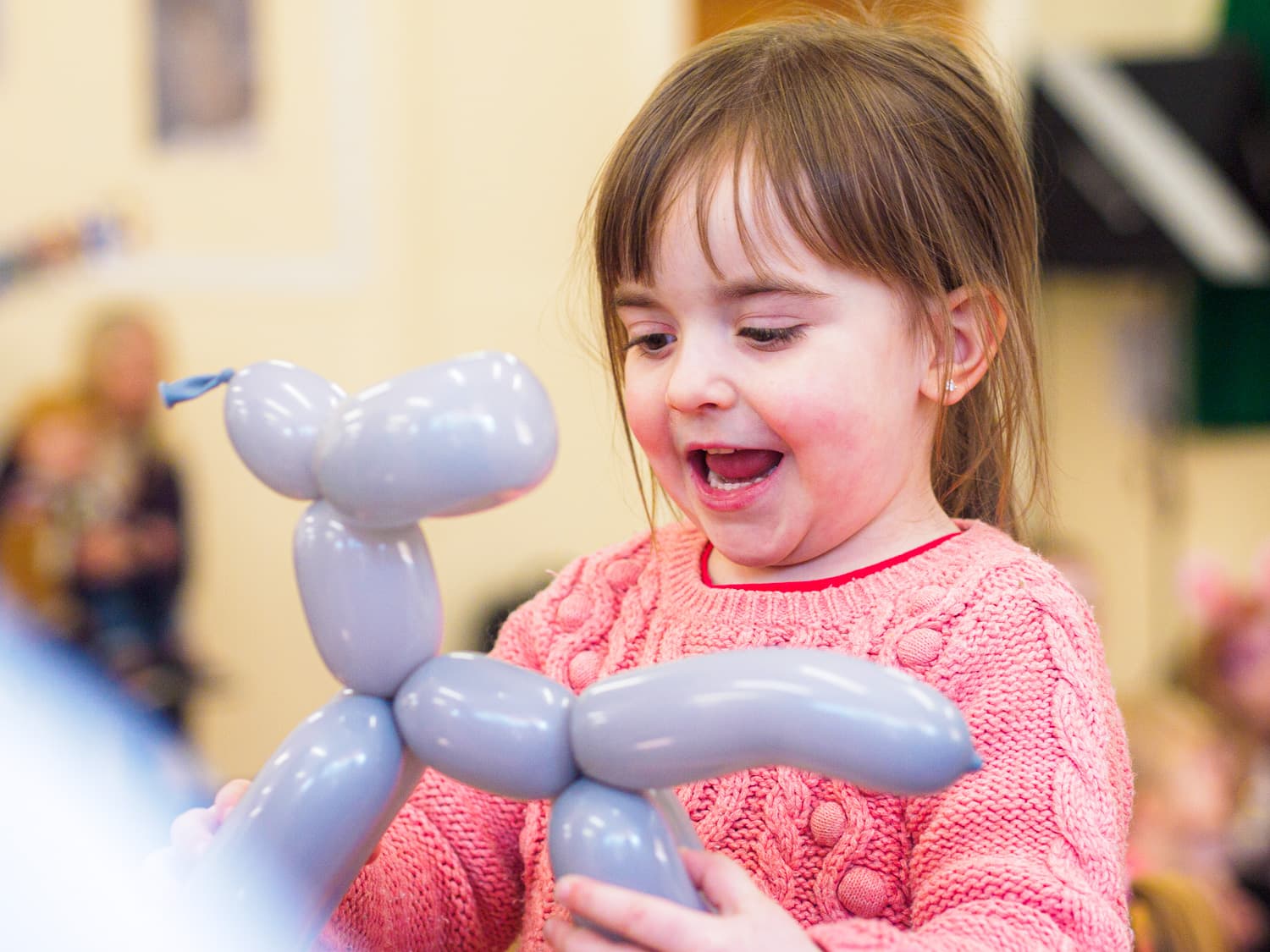 A child with a animal balloon dog
